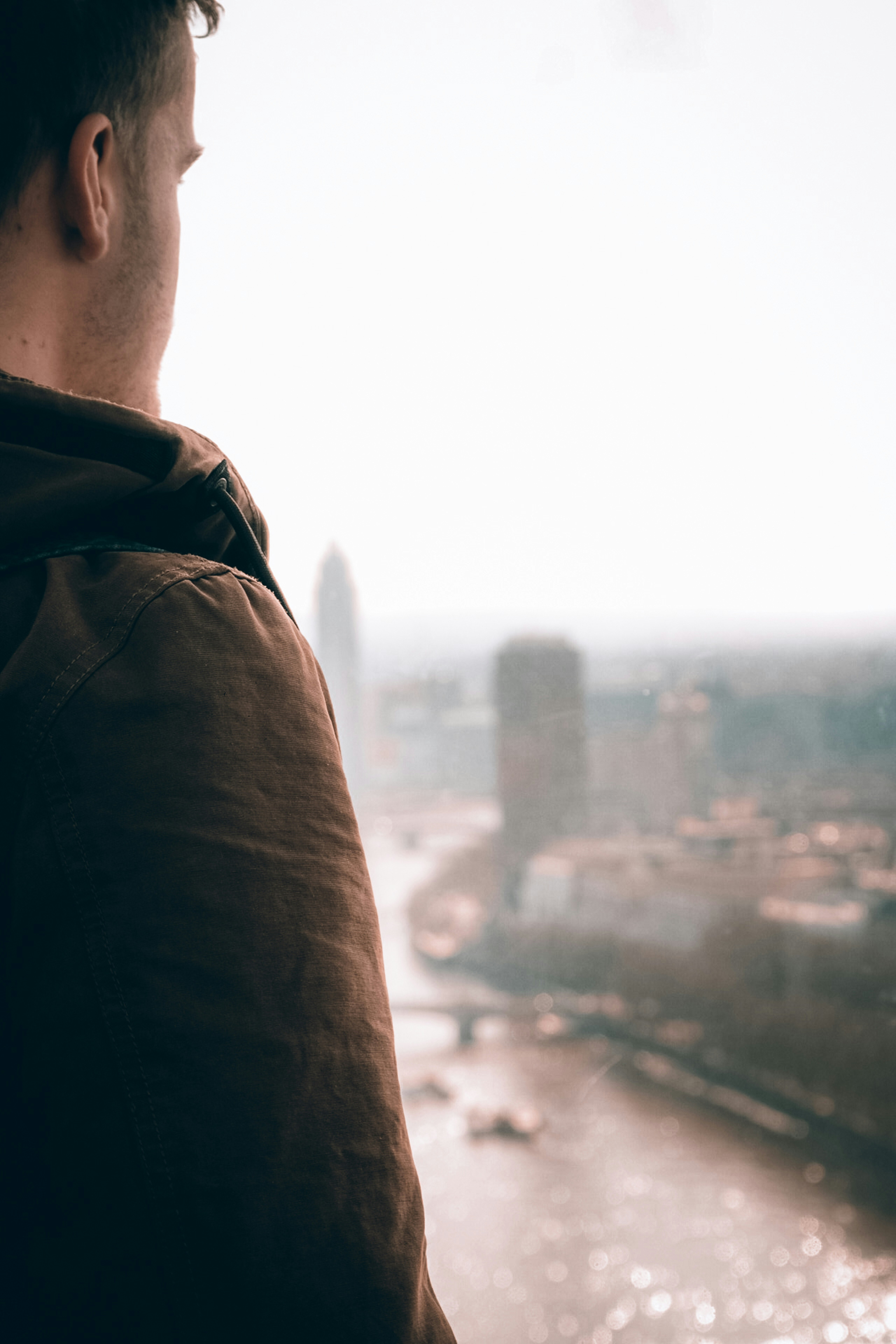 man in black jacket looking at the city during daytime